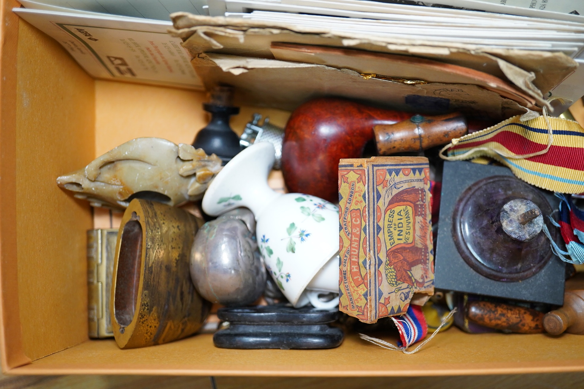 A box of assorted curiosities including vesta cases, one in the form of a skull, medals, section of Japanese inro and miniatures. Condition - varies